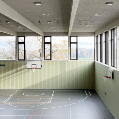 Wandbekleidung (Holzleisten) und Holzwolle-Decken in der Mehrzweckhalle in St. Erhard. Realisiert durch Röösli Funktionsdecken.
