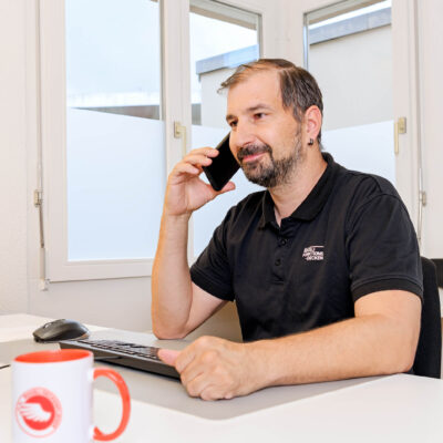 Projektleiter telefoniert mit Kunde und klärt offene Frage. Röösli Funktionsdecken.